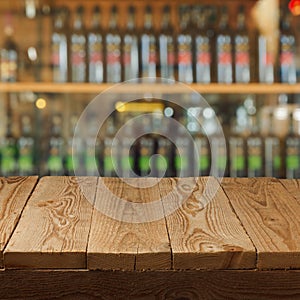 Empty wooden table over wine store background