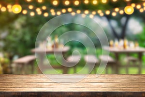Empty wooden table with party in garden background blurred