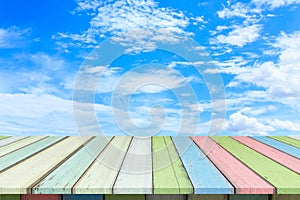 Empty wooden table or plank with blue sky and cloud background.