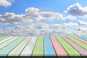 Empty wooden table or plank with blue sky and cloud background for product display.