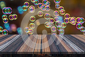 Empty wooden table or plank with bokeh of rainbow soap bubbles from the bubble blower on background for product display.