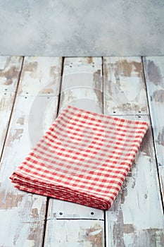 Empty wooden table with red checked tablecloth background