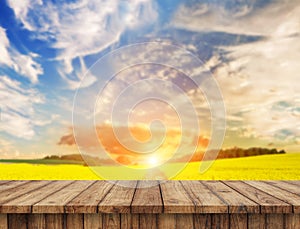 Empty wooden table in sunflower field with blue sky. the background for product display template