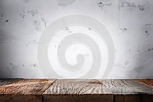 Empty wooden table surface with defocused concrete wall