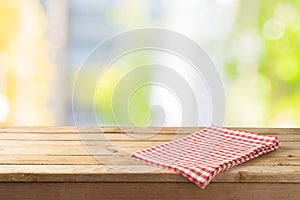 Empty wooden table with table cloth over abstract bokeh background