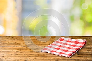 Empty wooden table with tablecloth over abstract bokeh background