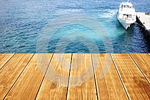 Empty wooden table or terrace on the sea background. Ship berth on the shore. Can be used as a table, pier, terrace.