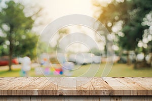 Empty wooden table top and Abstract blurred light bokeh and blur background of garden trees in sunlight. product display template