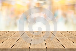 Empty wooden table top on blurred background at shopping mall