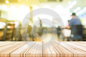 Empty wooden table top with blurred coffee shop interior background.