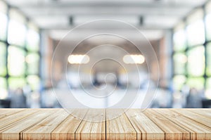 Empty wooden table top with blurred coffee shop or restaurant interior background