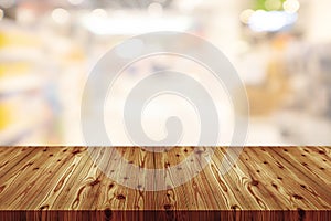 Empty wooden table top with blurred of department store background, Abstract background can be used for display or montage your