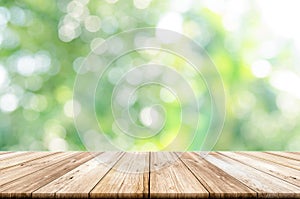 Empty wooden table top with blurred green garden background.