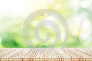 Empty wooden table top with blurred green garden background.