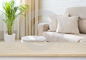 Empty wooden table top on blurred living room interior background