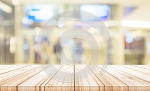 Empty wooden table top with blurred modern shopping mall background.