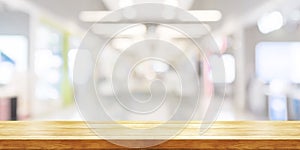 Empty wooden table top with blurred modern shopping mall background. Panoramic banner