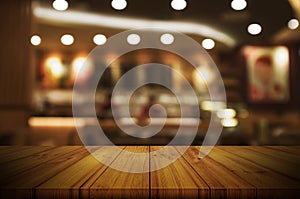 Empty wooden table top with blurred restaurant or cafe light background.