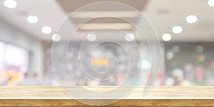 Empty wooden table top with blurred restaurant or cafe light background. Panoramic banner. Abstract background