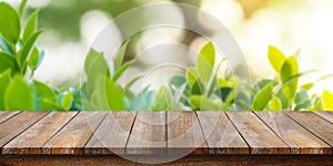 Empty of wooden table top with blurry green leaf and bokeh background. For montage product display or design key visual layouts