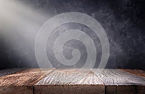 Empty wooden table top with defocused dark concrete wall background