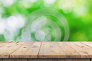 Empty wooden table top and green bokeh display montage for product with space.