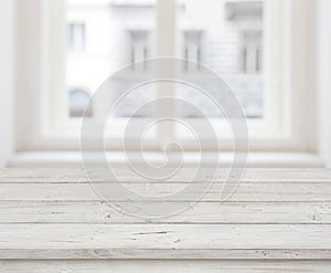 Empty wooden table top for product display over blurred window