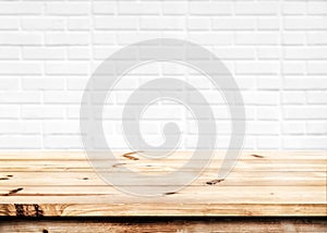Empty wooden table with white brick wall background.