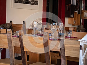 Empty Wooden Tables with Crystal Wine tasting Glasses Set for Outdoor Lunch in a Tuscan Village in Italy