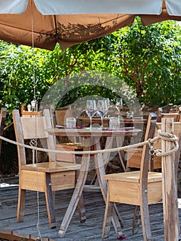 Empty Wooden Tables with Crystal Wine tasting Glasses Set for Outdoor Lunch in a Tuscan Village in Italy