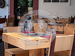 Empty Wooden Tables with Crystal Wine tasting Glasses Set for Outdoor Lunch in a Tuscan Village in Italy