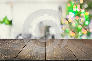 Empty wooden tabletop for display products and blurred kitchen with Christmas tree as background.