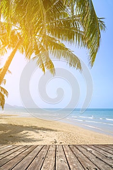 Empty wooden terrace over tropical island beach with coconut palm