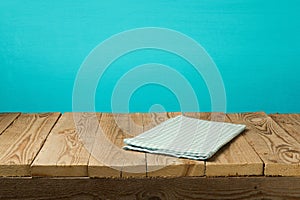 Empty wooden vintage table with tablecloth over blue wall background