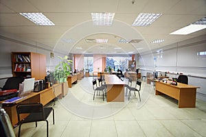 Empty working tables with armchairs in modern office