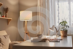 Empty workplace of modern freelancer, open laptop computer, flower in pot, smart phone, copybook on desk in stylish home office