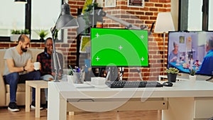 Empty workspace table with greenscreen display on computer