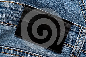 Empty worn leather patch on blue jeans. Empty space for writing. Blank leather jeans label
