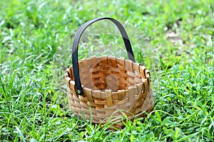 An empty woven basket on the green grass