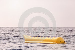 Empty yellow banana boat lying in the sea