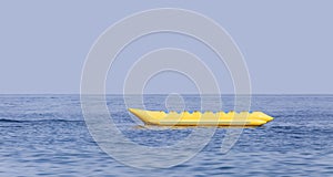 Empty yellow banana boat lying in the sea