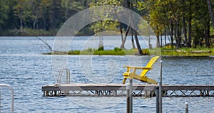 Empty yellow deck chair on a dock on the lake.