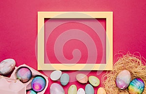 empty yellow frame with colorful easter eggs pink background. High quality photo