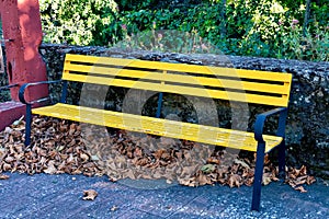 Empty yellow park bench.