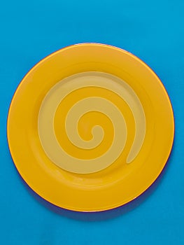 Empty yellow plate on blue