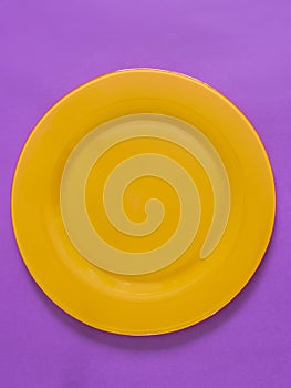Empty yellow plate on purple