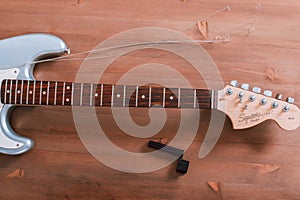 EMPURIABRAVA, SPAIN - FEBRUARY 17, 2021 Guitar master changing guitar strings on Fender Squier Strat, top view