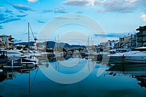 Empuriabrava spanish town in view of main water channel with boats at dusk. Landscape of the catalan town in the Costa Brava