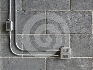 EMT PIPE Electrical Metallic Tubing and junction box on the grey bricks wall in construction site on building