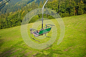 Emtpy chairlift in ski resort. Mountains and hills with in Summer with green trees